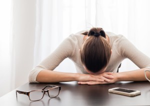 woman-with-eyeglasses-and-head-on-table